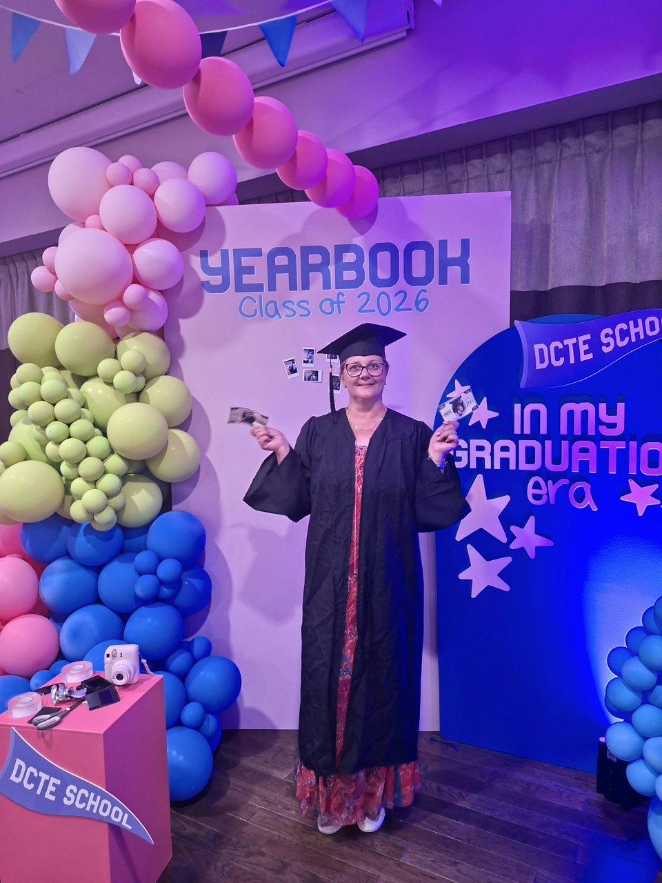 Mihaela Dumitrascu à la DCTE School, à Paris, en tenue de remise de diplôme devant un décor de ballons