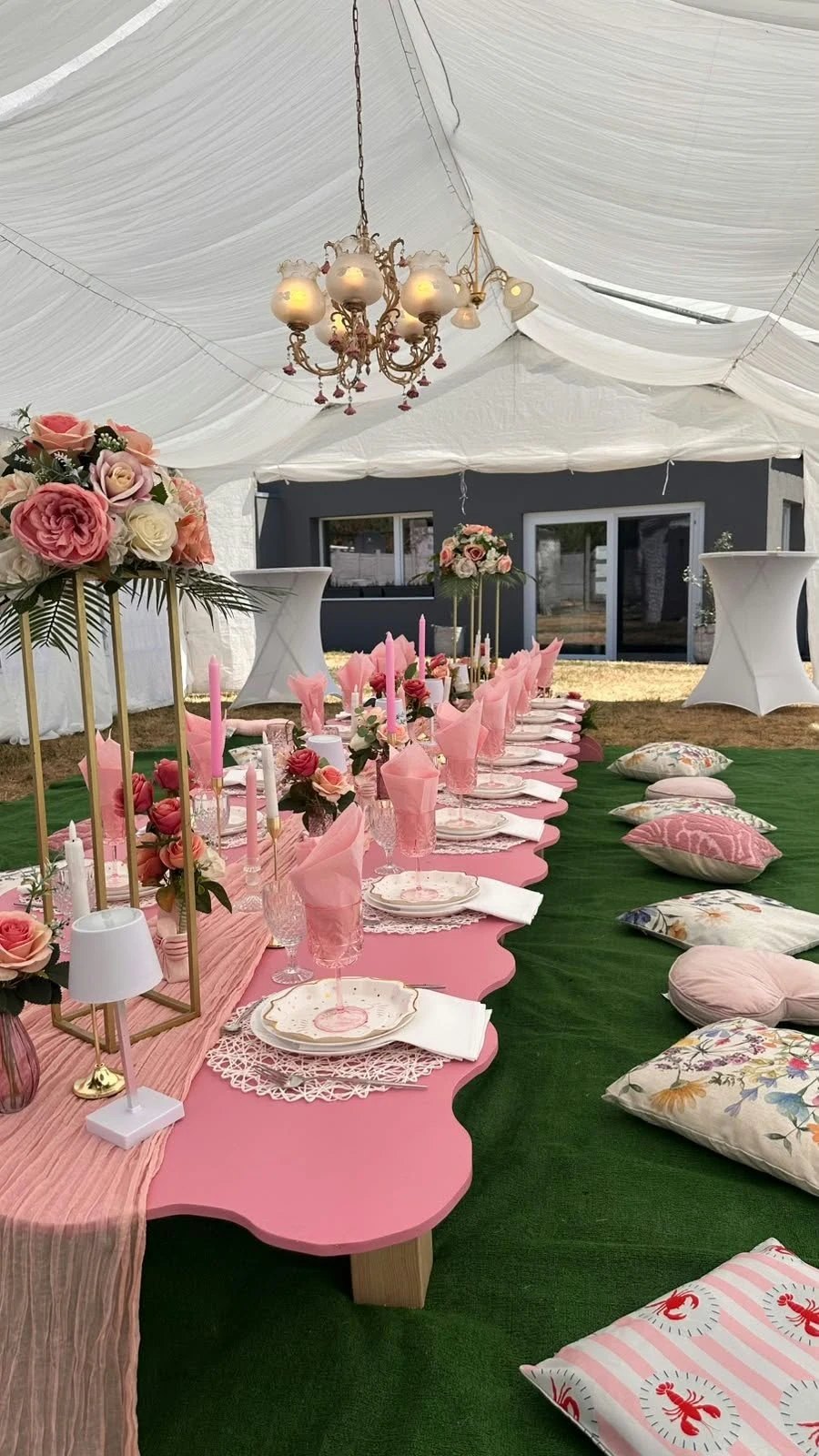 Table rose décorée de fleurs sous une tente de réception